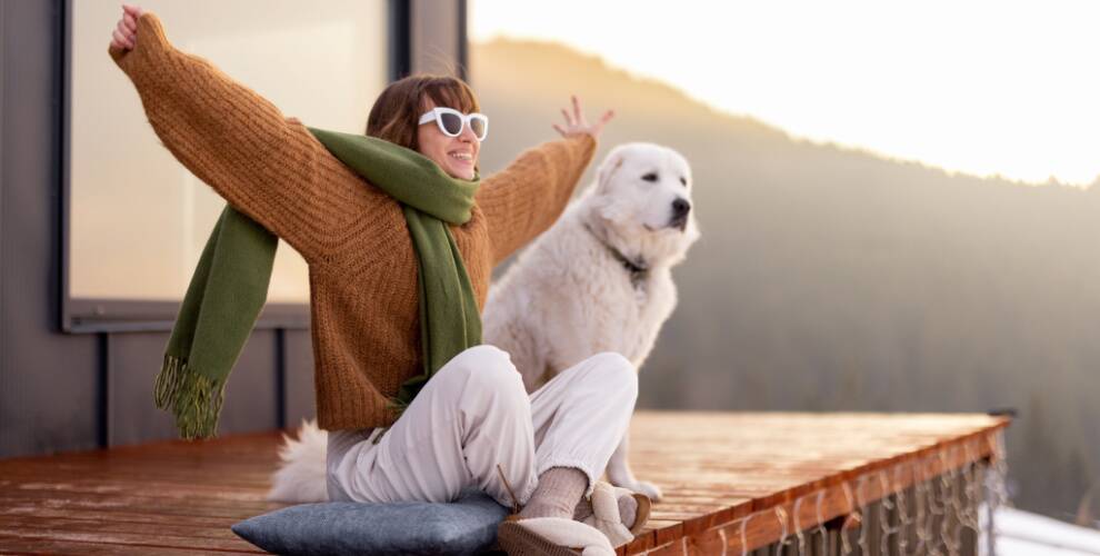Frau mit Hund im Ferienhaus in der Natur