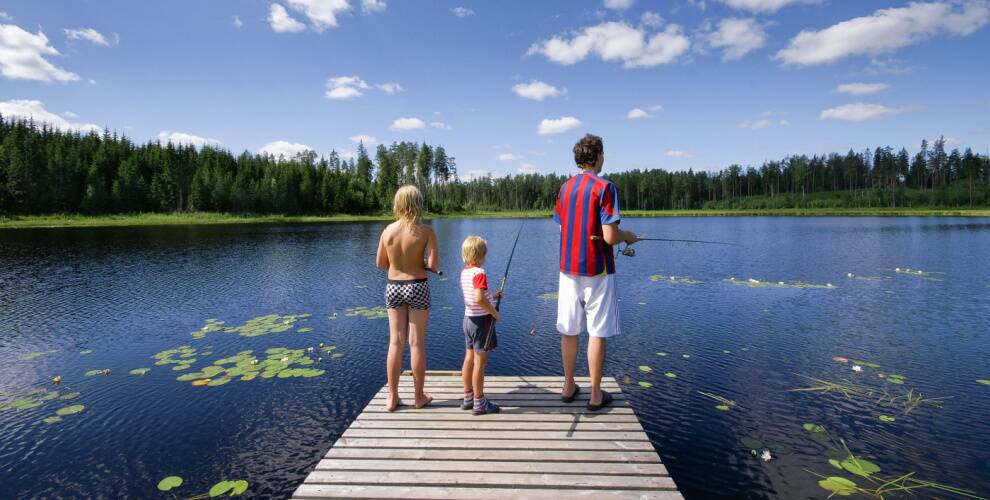 Familie mit Kindern beim Angeln am See